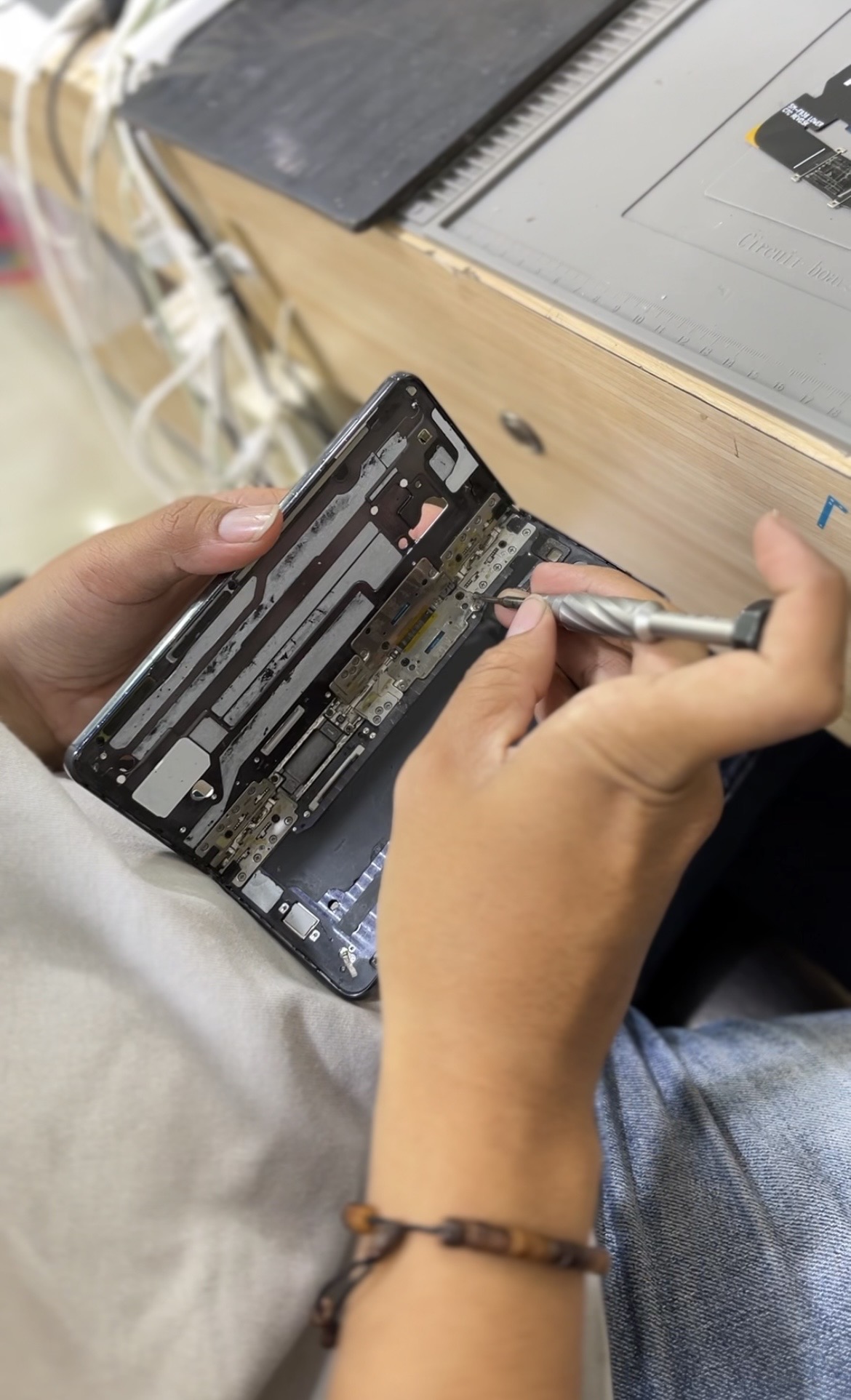 Teknisi memperbaiki area hinge dan flexible Samsung Z Fold 4 di Bengkel Henpon